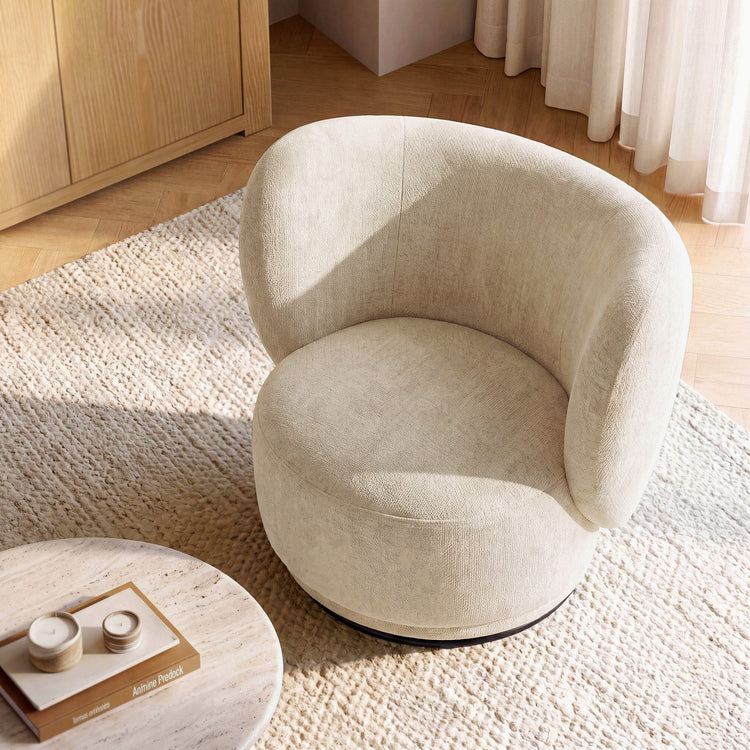 Rounded upholstered accent chair has a continuous curved back and seat, A dark circular base is visible below