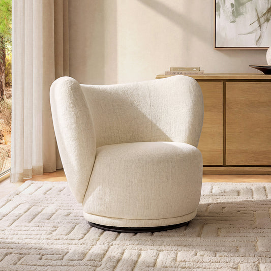 Cream upholstered chair has a broad wraparound back, rounded seat, and dark circular base