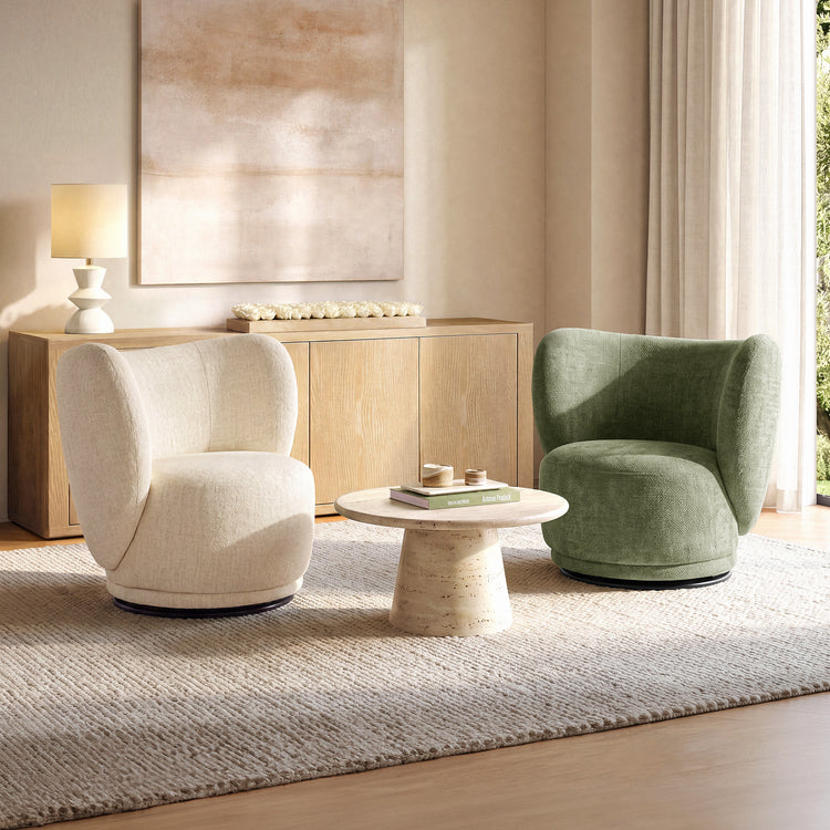 Cream and green upholstered chairs face a round veined coffee table with a tapered pedestal
