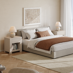Two light nightstands with drawers and open shelves flank a bed