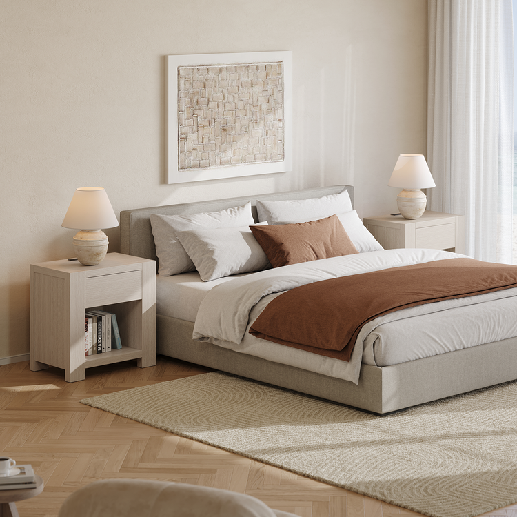 Two light nightstands with drawers and open shelves flank a bed