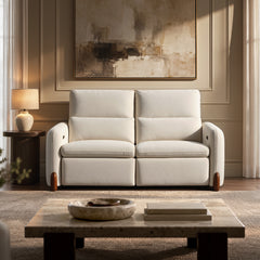 White two-seat sofa with padded backrests and wood-trimmed front feet in a living room.