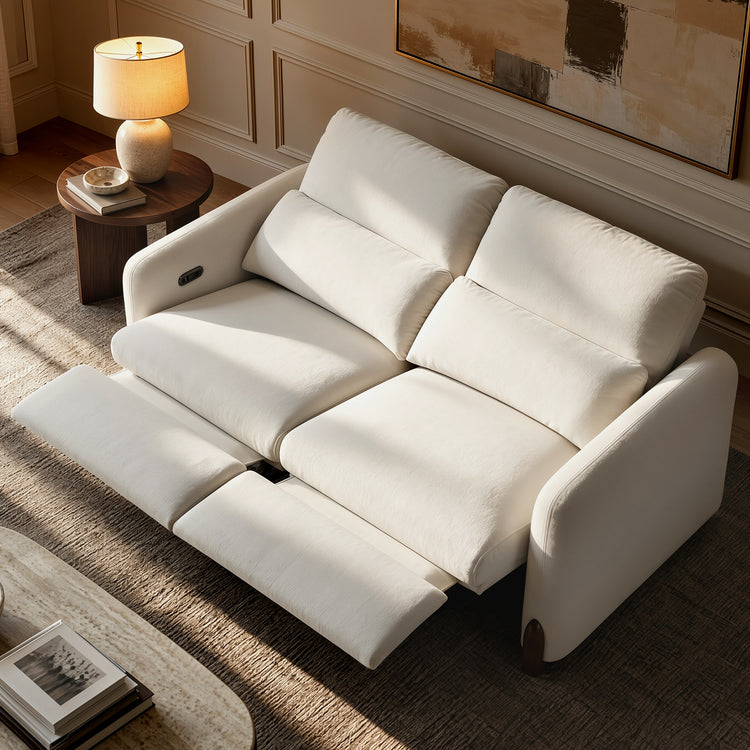 White two-seat reclining sofa with both footrests extended in a living room.