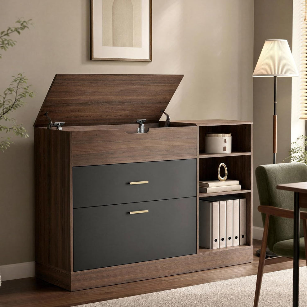 A dark wood cabinet with its top compartment open, two charcoal drawer fronts, and open shelves holding books and a container stands beside a floor lamp and chair.