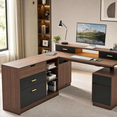 Brown L-shaped desk with black drawer fronts, gold-colored handles, open shelves and a raised monitor shelf, arranged with a monitor, keyboard, mouse, lamp and potted plant.