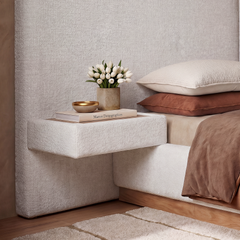 A rectangular upholstered shelf projects from the matching headboard beside the bed