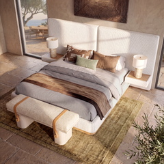 A bed with a split upholstered headboard stands between two bedside tables