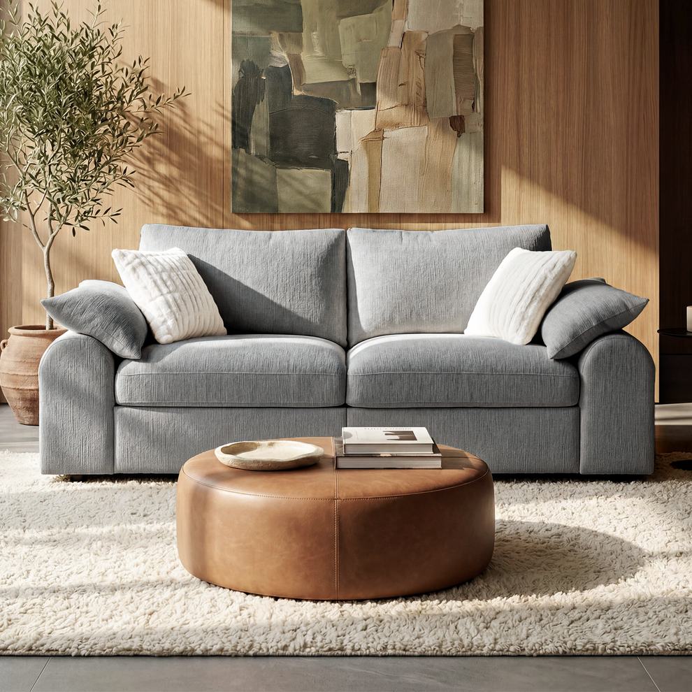 Gray two-seat sofa with rounded arms and accent pillows in a living room.