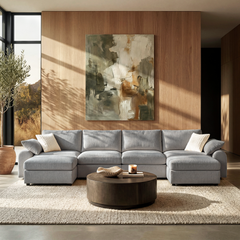 Gray U-shaped sectional sofa with two ottomans in a sunlit modern living room