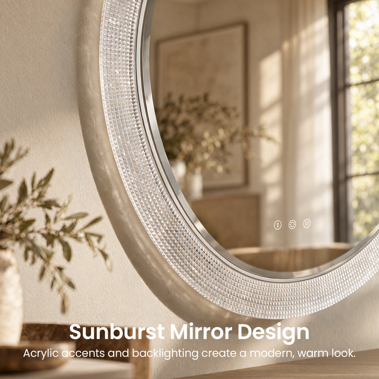 Close-up of a round wall mirror with a wide, faceted border and three white control symbols, reflecting a sunlit window, framed artwork and leafy branches.