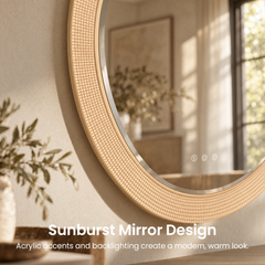 Close-up of a round mirror with a glowing gold-colored, geometric textured border and three illuminated symbols, reflecting a window, framed artwork and leafy branches.