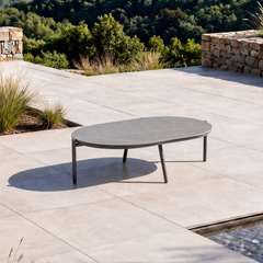 The low oval tabletop is supported by four slender legs