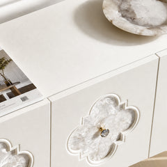 The cabinet front contains a quatrefoil-shaped inset filled with faceted translucent pieces