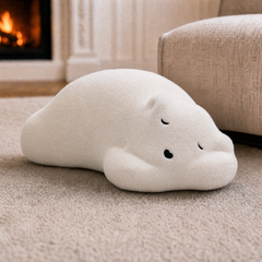 One white sleeping-dog-shaped plush cushion is shown on the floor