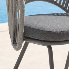 Close-up of gray cord-wrapped chair frame and dark textured seat cushion