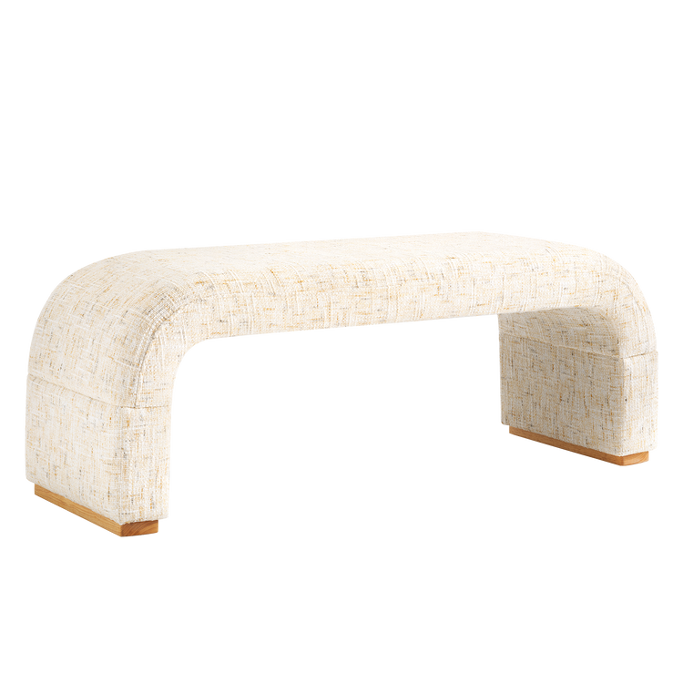 Cream upholstered bench with a textured weave, rounded corners, broad slab legs and short brown feet.