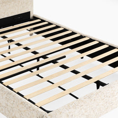Close-up of a cream upholstered bed frame with evenly spaced pale slats, black support bars and legs, and no mattress.