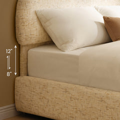 Diagram of a bed with a cream textured frame, white bedding and pillows, and vertical arrows beside the mattress labeled 8 and 12 inches.