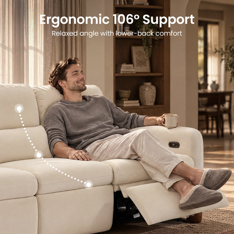 Man holding a mug while reclining on a cream sectional with the footrest extended.