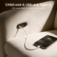 Phone connected to a charging port built into a cream upholstered chair.