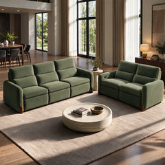 Green three-seat and two-seat sofas arranged in a sunlit living room with a round coffee table.