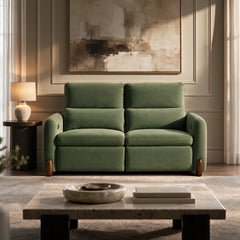 Green upholstered two-seat sofa in a sunlit living room.