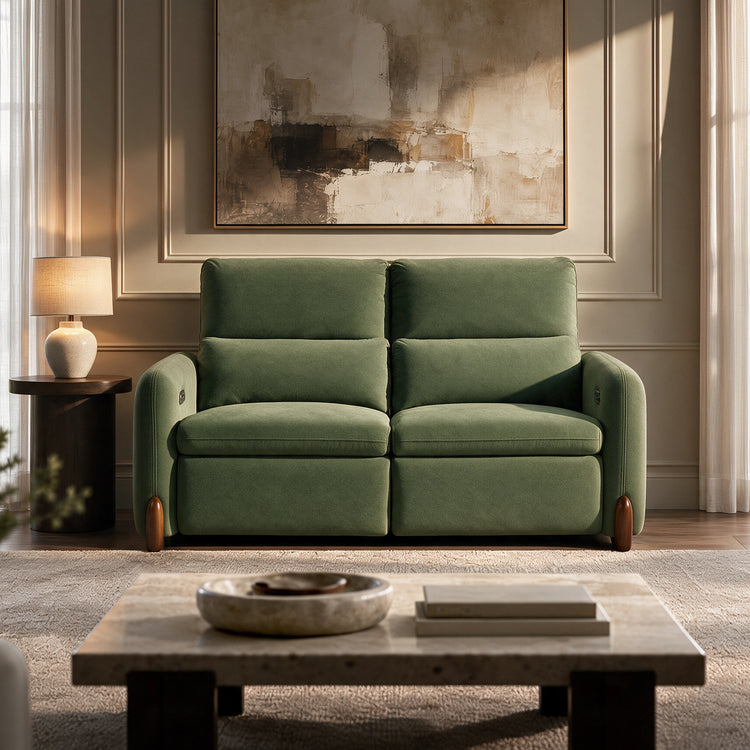 Green upholstered two-seat sofa in a sunlit living room.