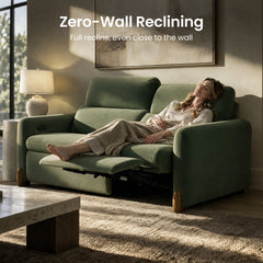 Woman relaxing on a green reclining sofa with an extended footrest.