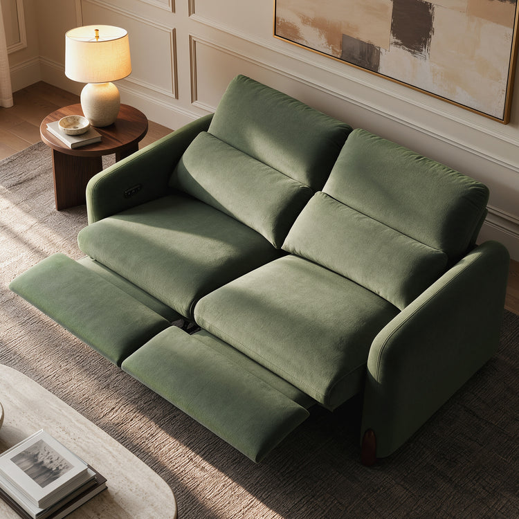 Green two-seat reclining sofa with both footrests extended in a staged living room.