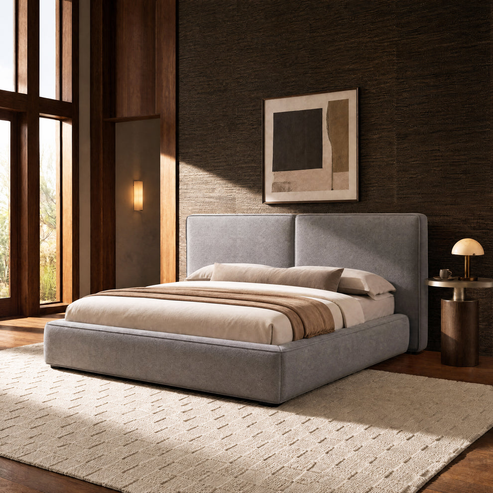 Grey upholstered bed with a tall split-panel headboard in a bedroom with dark walls and large windows